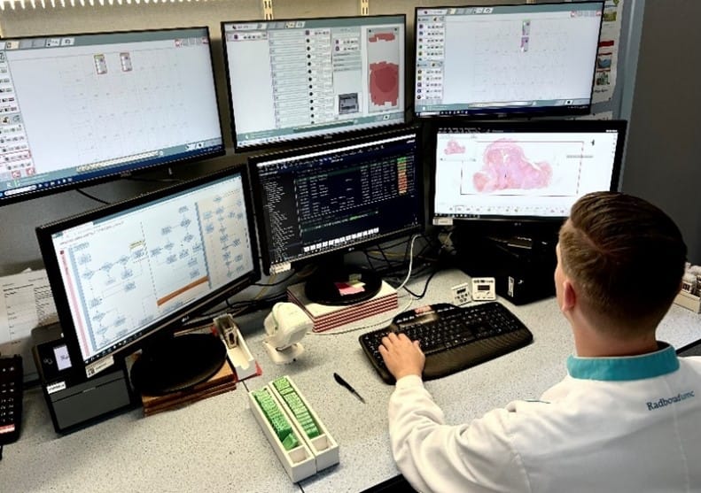 Histology lab technician reviewing the automated quality control results from AiosynQC at Radboudumc's digital pathology laboratory
